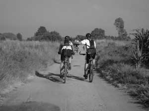 Two men biking side by side.